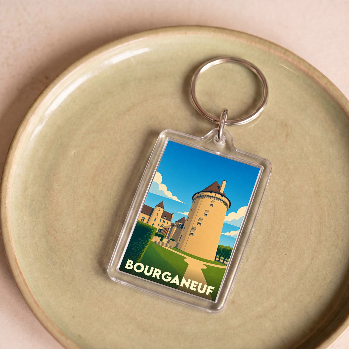 Porte-clés souvenir de la ville de Bourganeuf avec une illustration stylisée de sa tour médiévale.