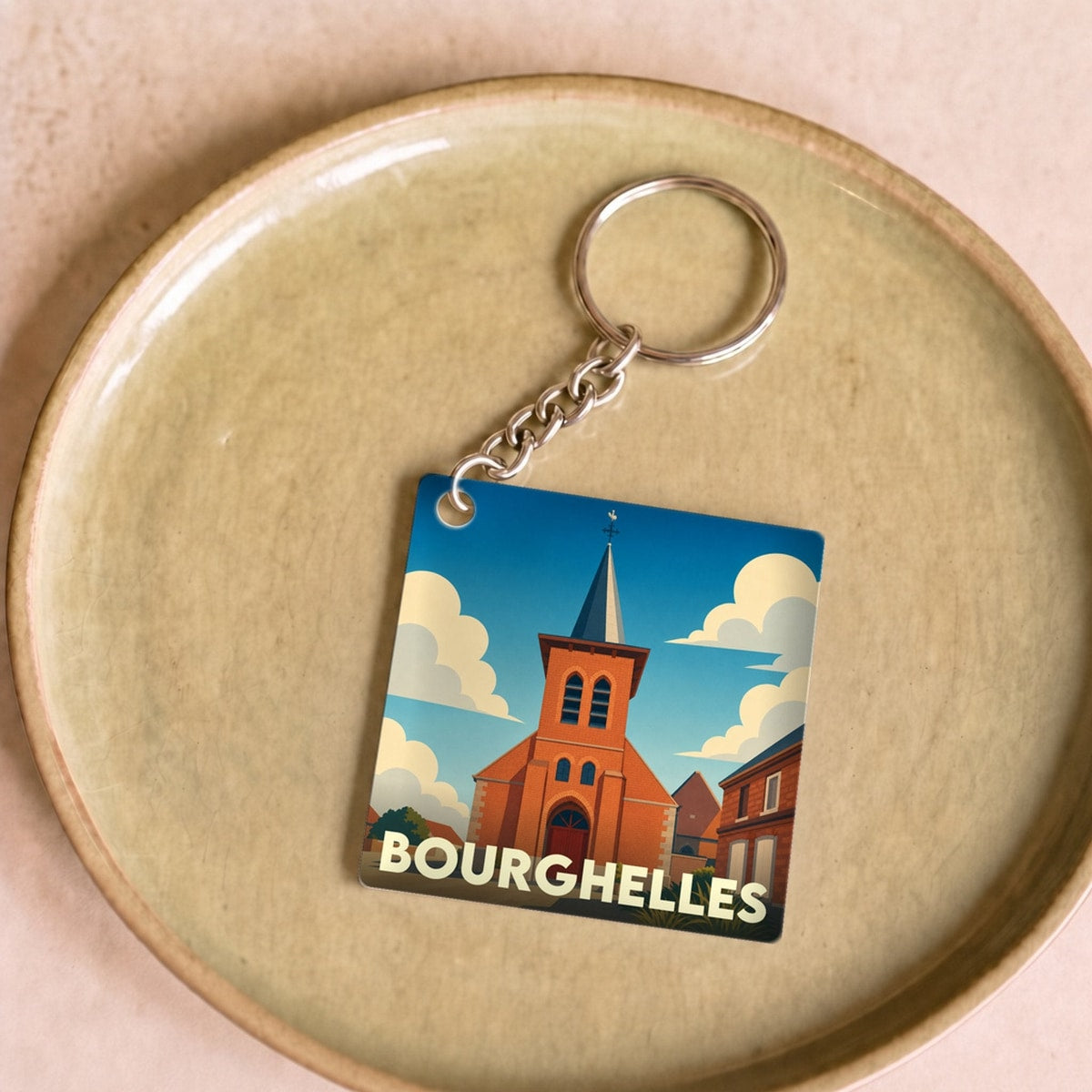 Porte-clés souvenir de la ville de Bourghelles avec une illustration stylisée de son église.