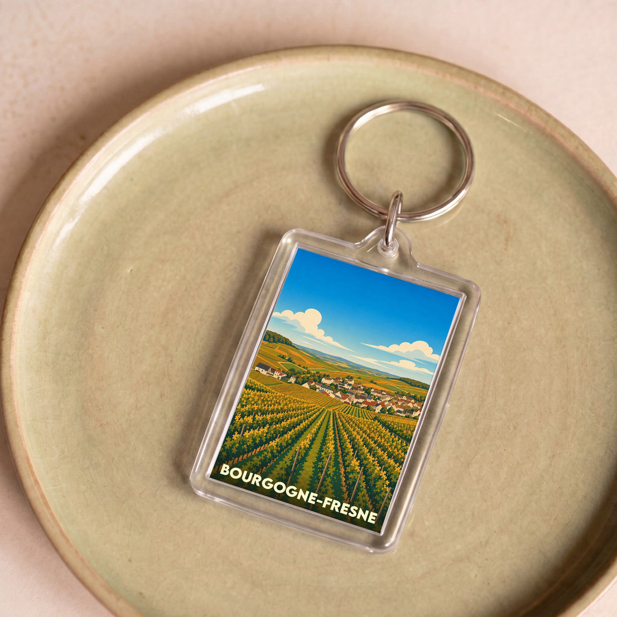 Porte-clés souvenir de la ville de Bourgogne-Fresne avec une illustration stylisée de vignobles.