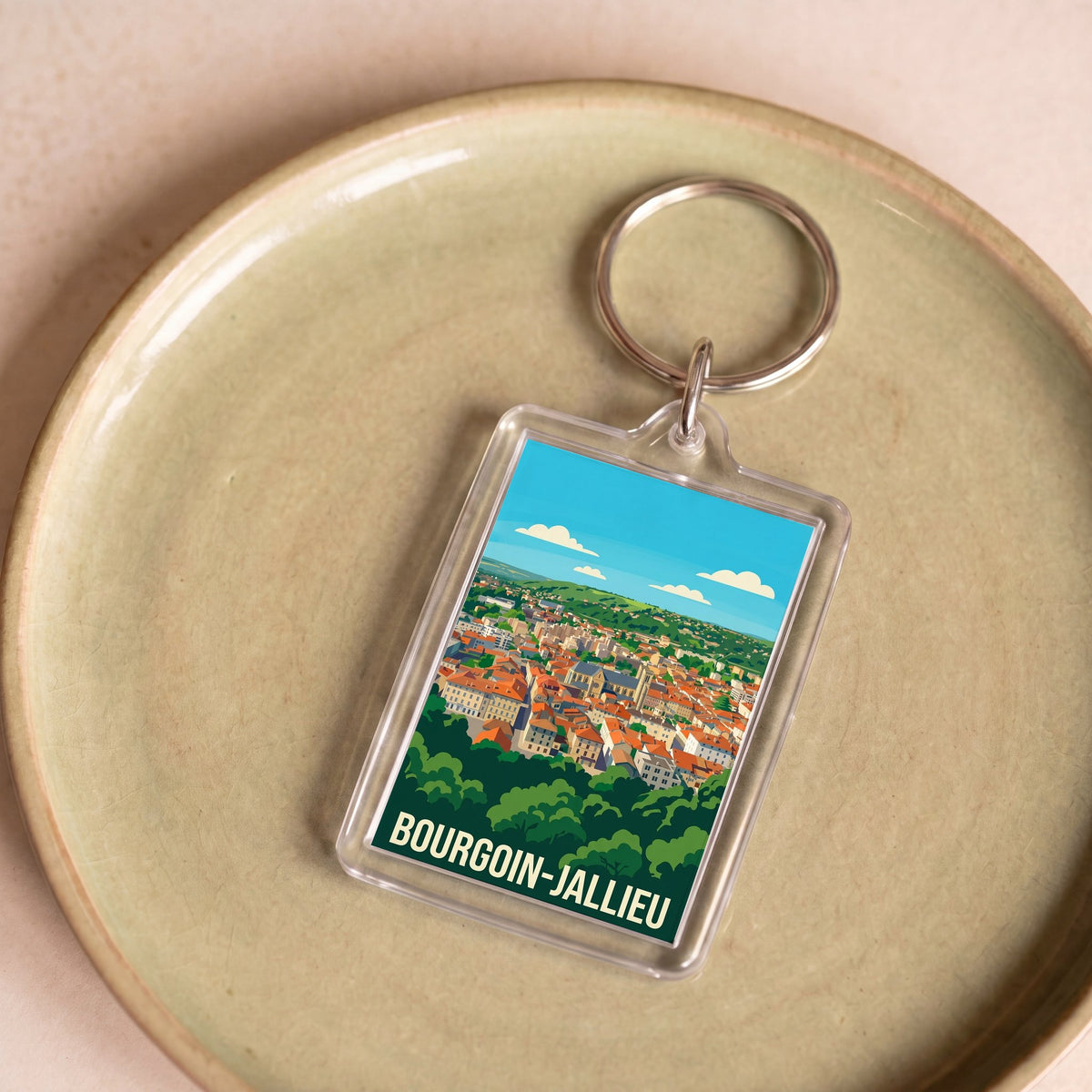 Porte-clés souvenir de la ville de Bourgoin-Jallieu avec une illustration stylisée de son paysage urbain.