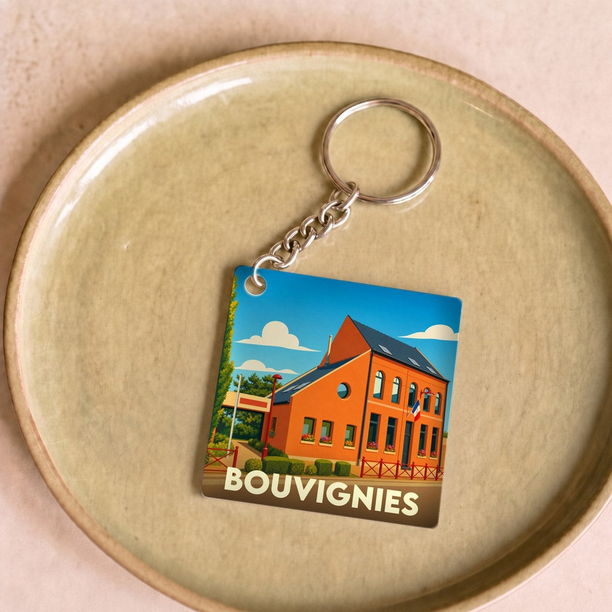 Porte-clés souvenir de la ville de Bouvignies avec une illustration stylisée d'un bâtiment local.