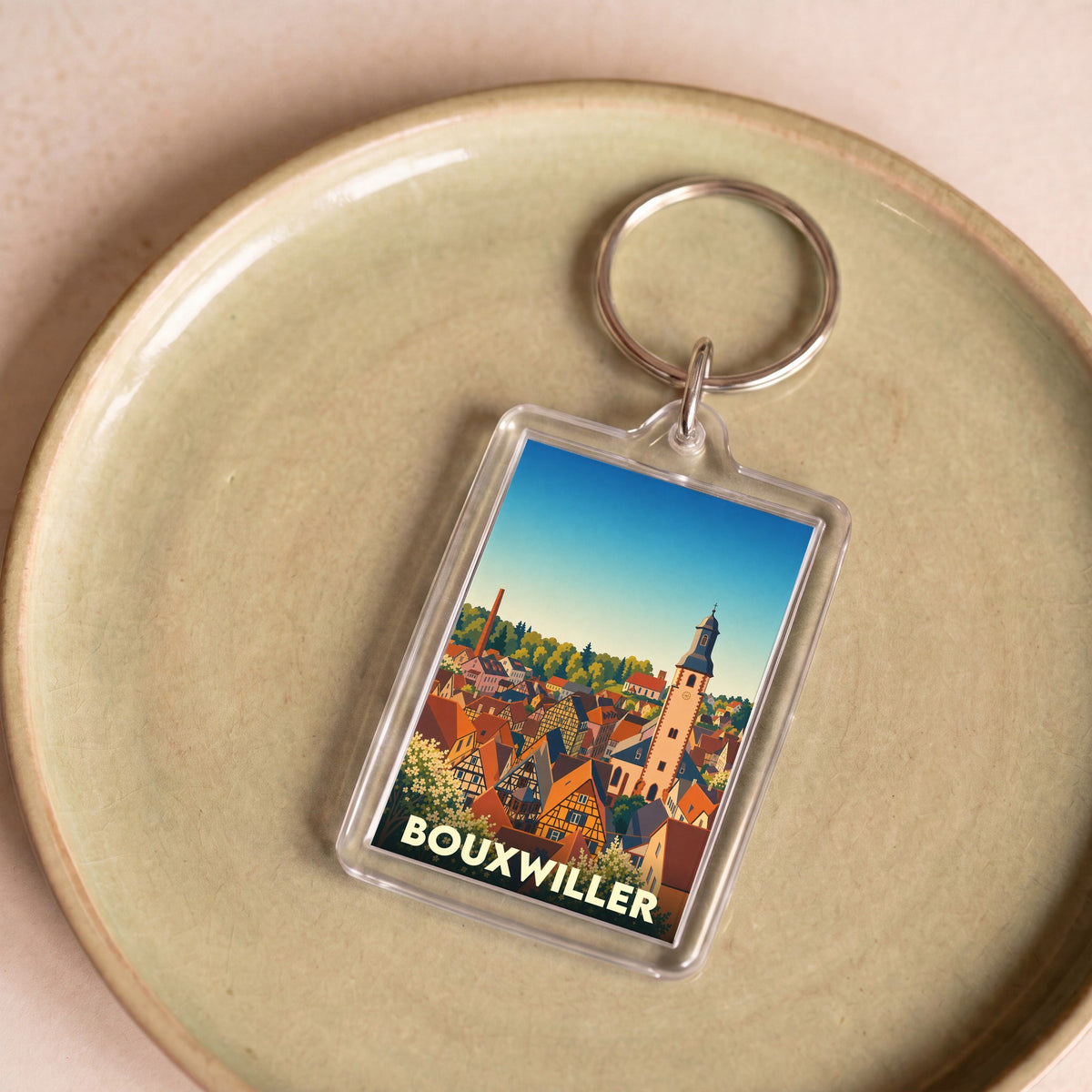 Porte-clés souvenir de la ville de Bouxwiller avec une illustration stylisée.