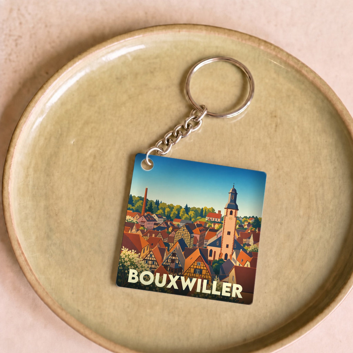 Porte-clés souvenir de la ville de Bouxwiller avec une illustration stylisée.