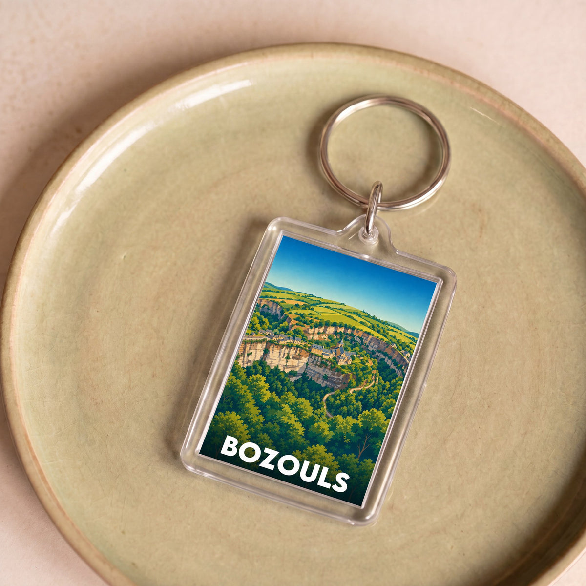 Porte-clés souvenir de la ville de Bozouls avec une illustration stylisée.