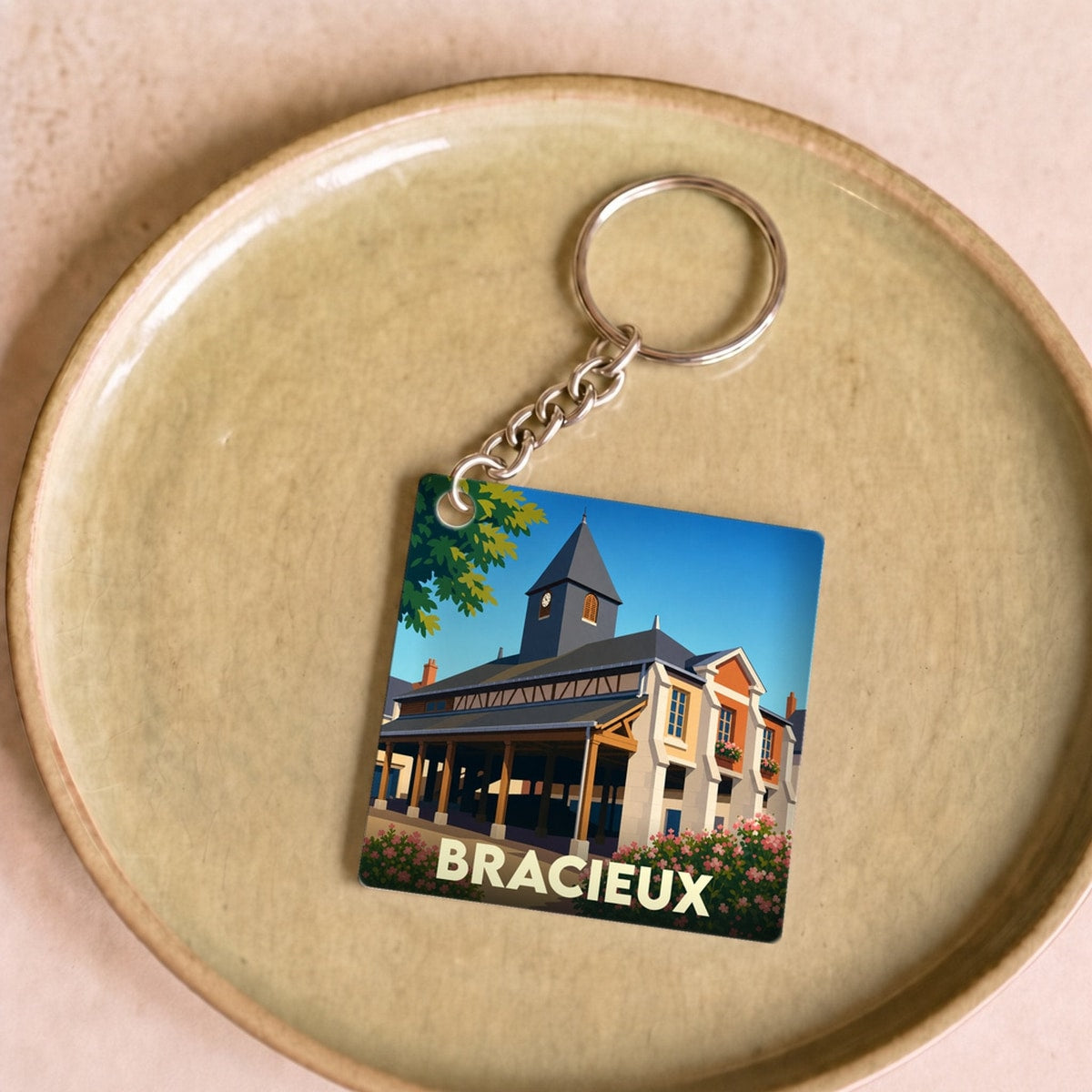 Porte-clés souvenir de la ville de Bracieux avec une illustration stylisée de ses halles historiques.