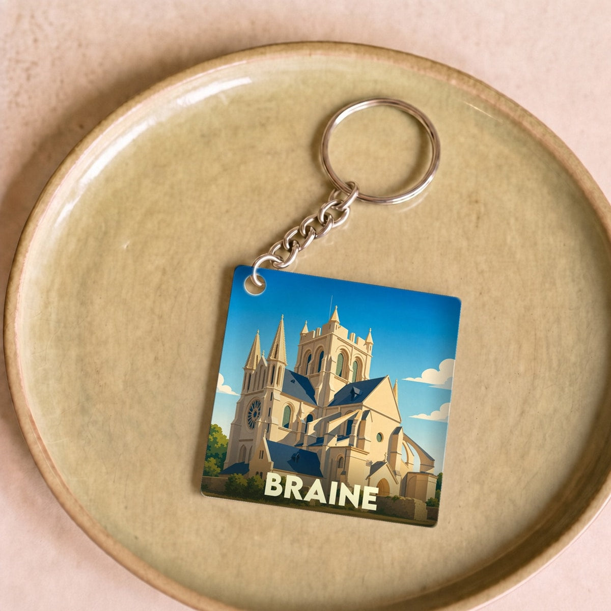 Porte-clés souvenir de la ville de Braine avec une illustration stylisée de son abbatiale.