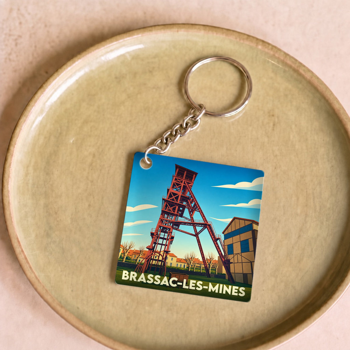 Porte-clés souvenir de la ville de Brassac-les-Mines avec une illustration stylisée d'un chevalement de mine.