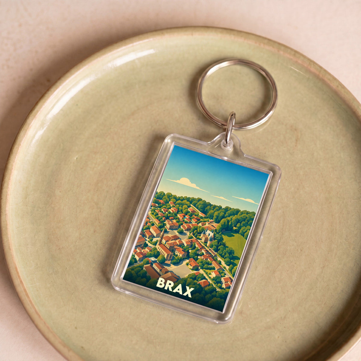 Porte-clés souvenir de la ville de Brax avec une illustration stylisée vue du ciel.