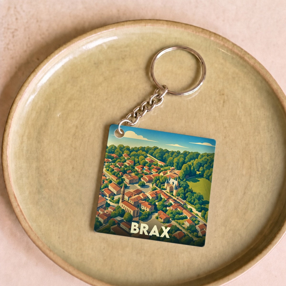 Porte-clés souvenir de la ville de Brax avec une illustration stylisée vue du ciel.