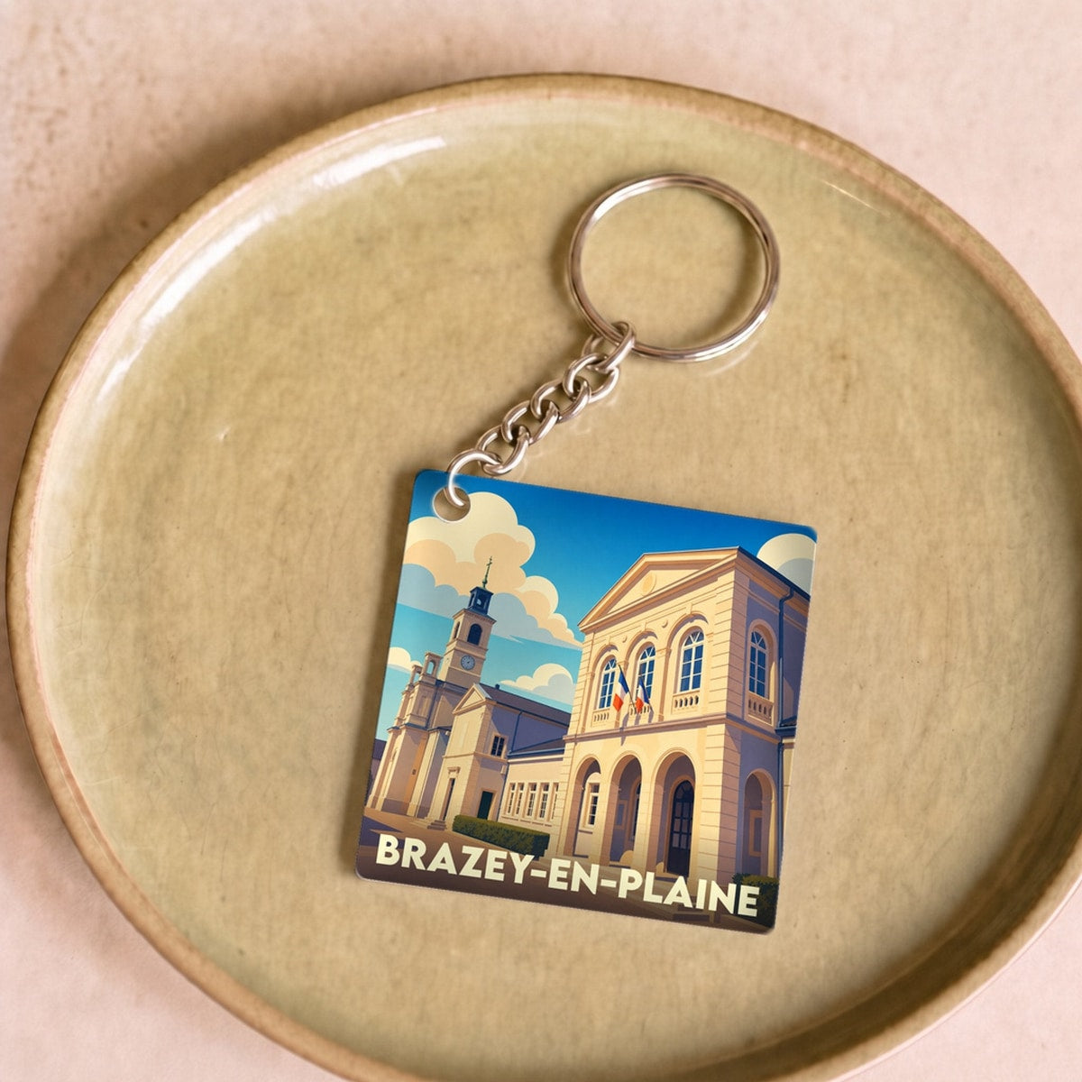 Porte-clés souvenir de la ville de Brazey-en-Plaine avec une illustration stylisée de son patrimoine.