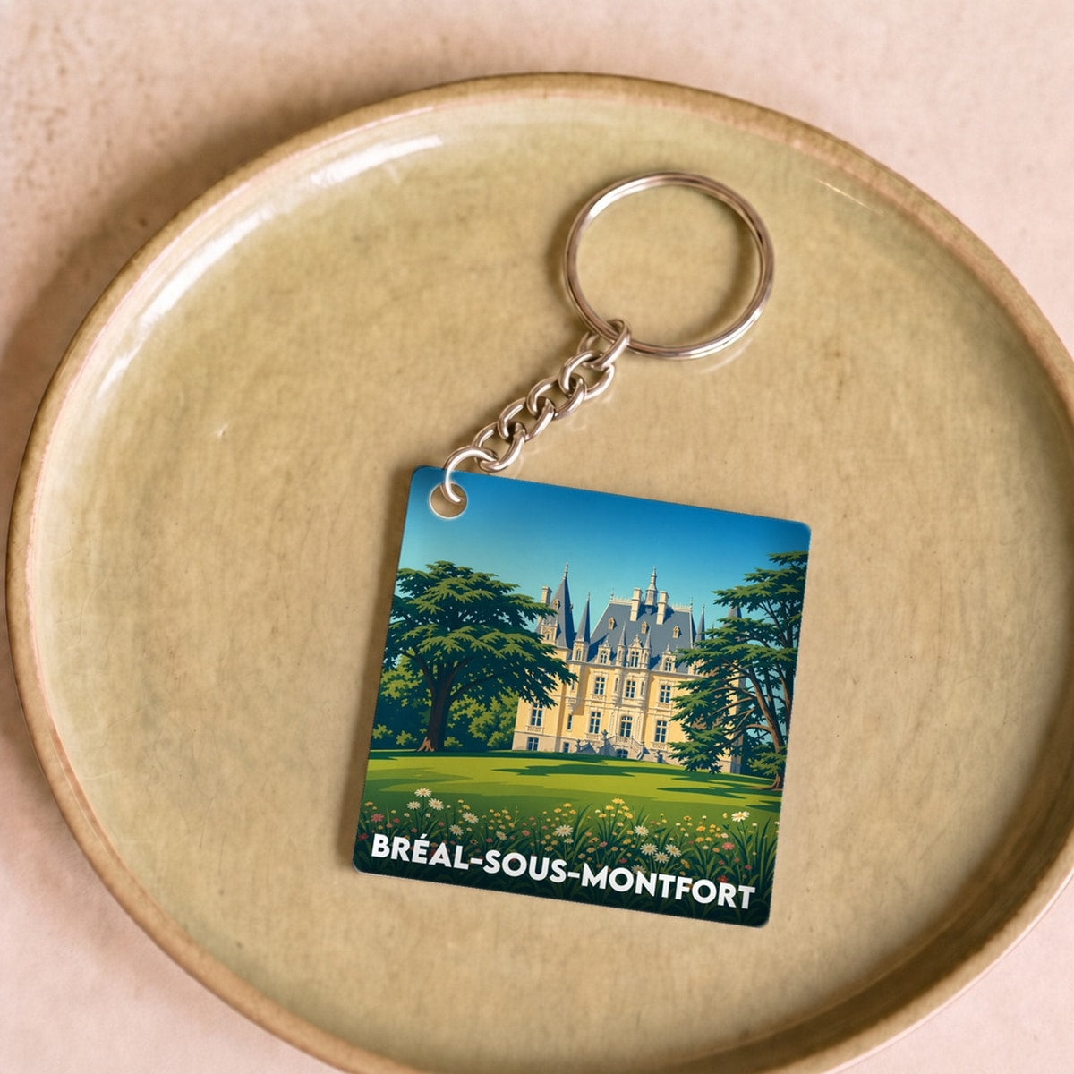 Porte-clés souvenir de la ville de Bréal-sous-Montfort avec une illustration stylisée de son château.