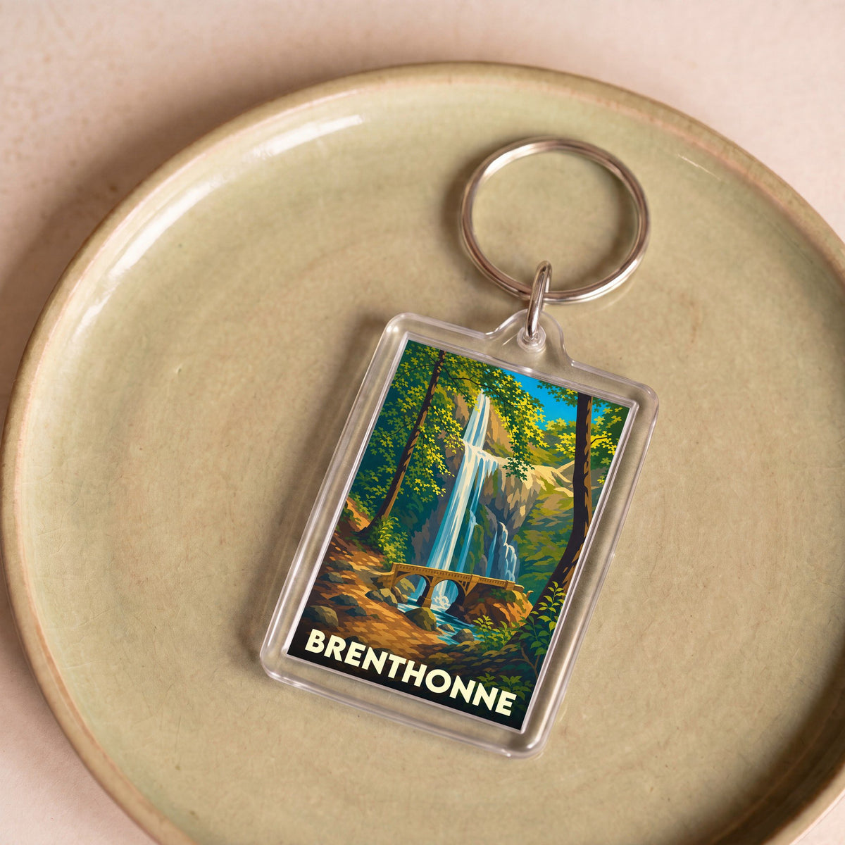 Porte-clés souvenir de la ville de Brenthonne avec une illustration stylisée d'une cascade.