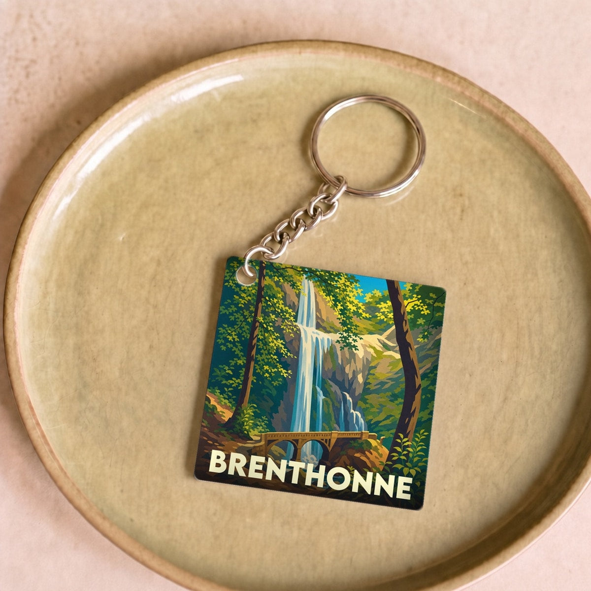 Porte-clés souvenir de la ville de Brenthonne avec une illustration stylisée d'une cascade.