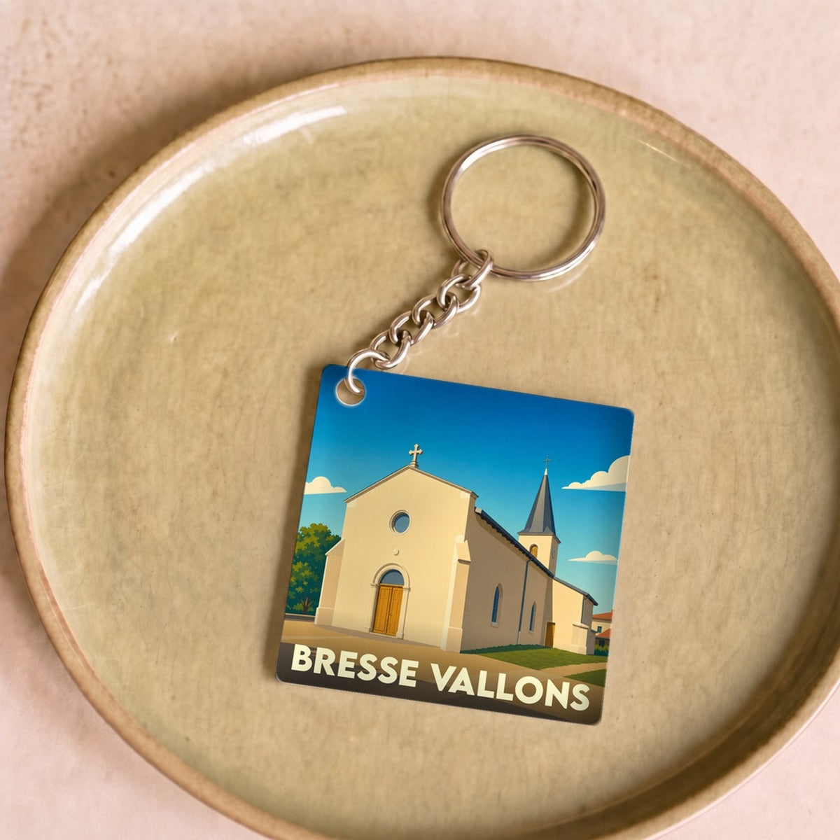 Porte-clés souvenir de la commune de Bresse Vallons avec une illustration stylisée de son église.