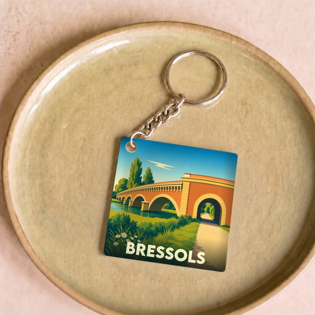 Porte-clés souvenir de la ville de Bressols avec une illustration stylisée d'un pont en briques.
