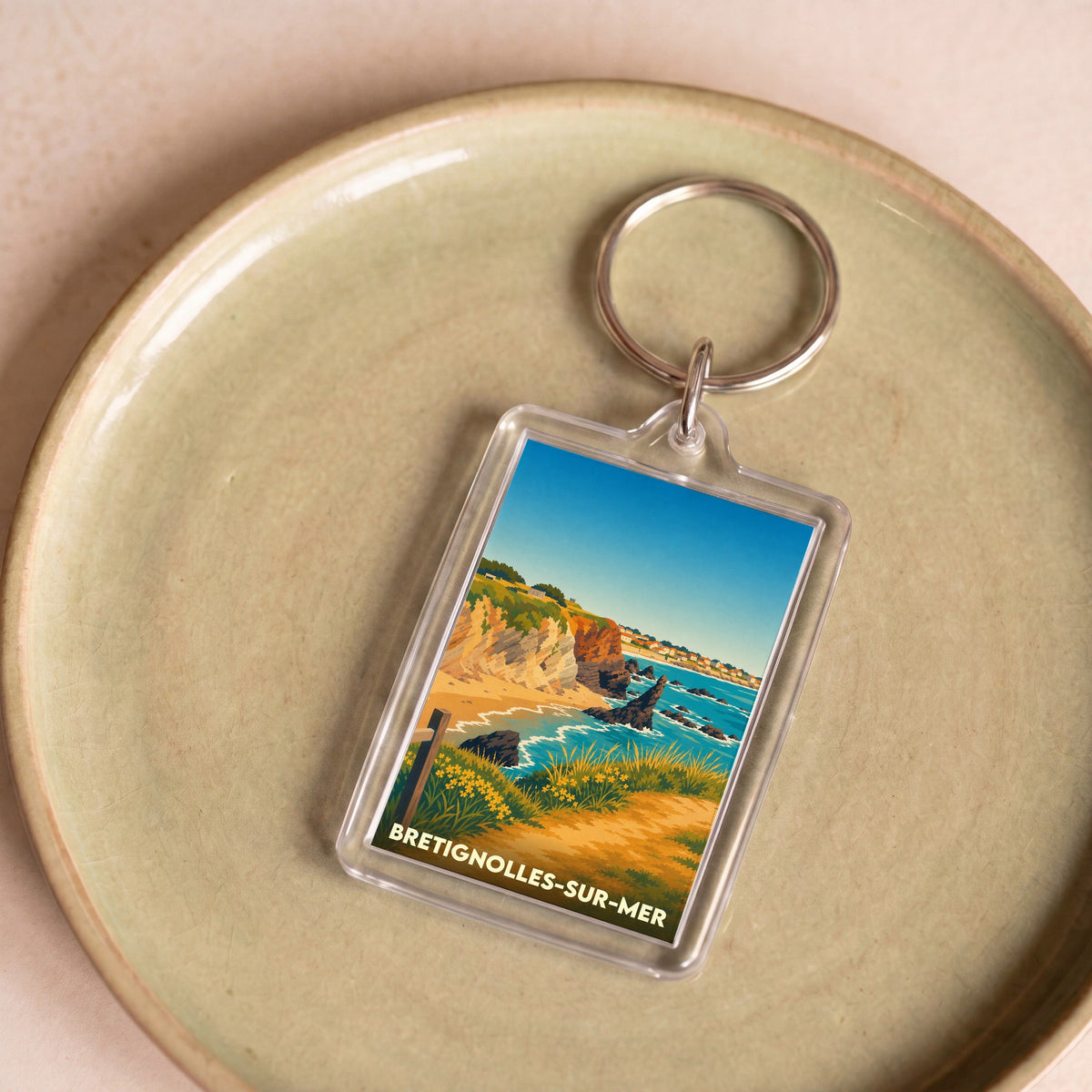 Porte-clés souvenir de la ville de Brétignolles-sur-Mer avec une illustration stylisée de son littoral.