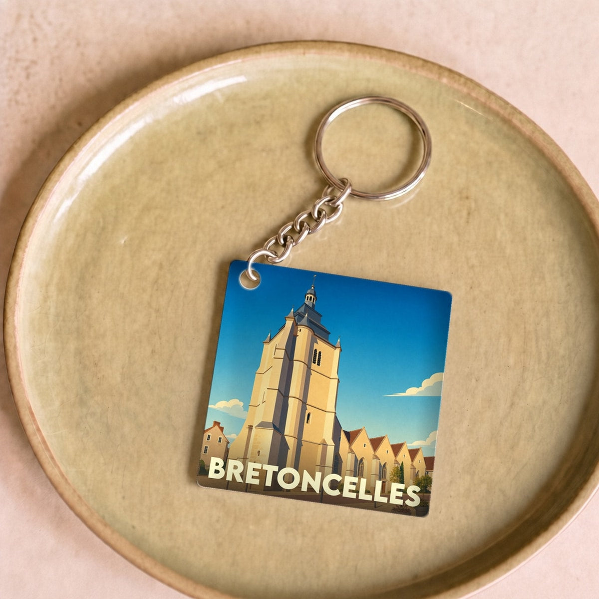 Porte-clés souvenir de la ville de Bretoncelles avec une illustration stylisée de son église.