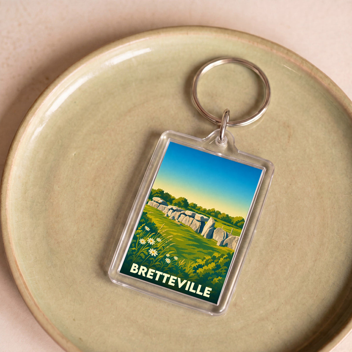 Porte-clés souvenir de la ville de Bretteville avec une illustration stylisée d'un monument mégalithique.