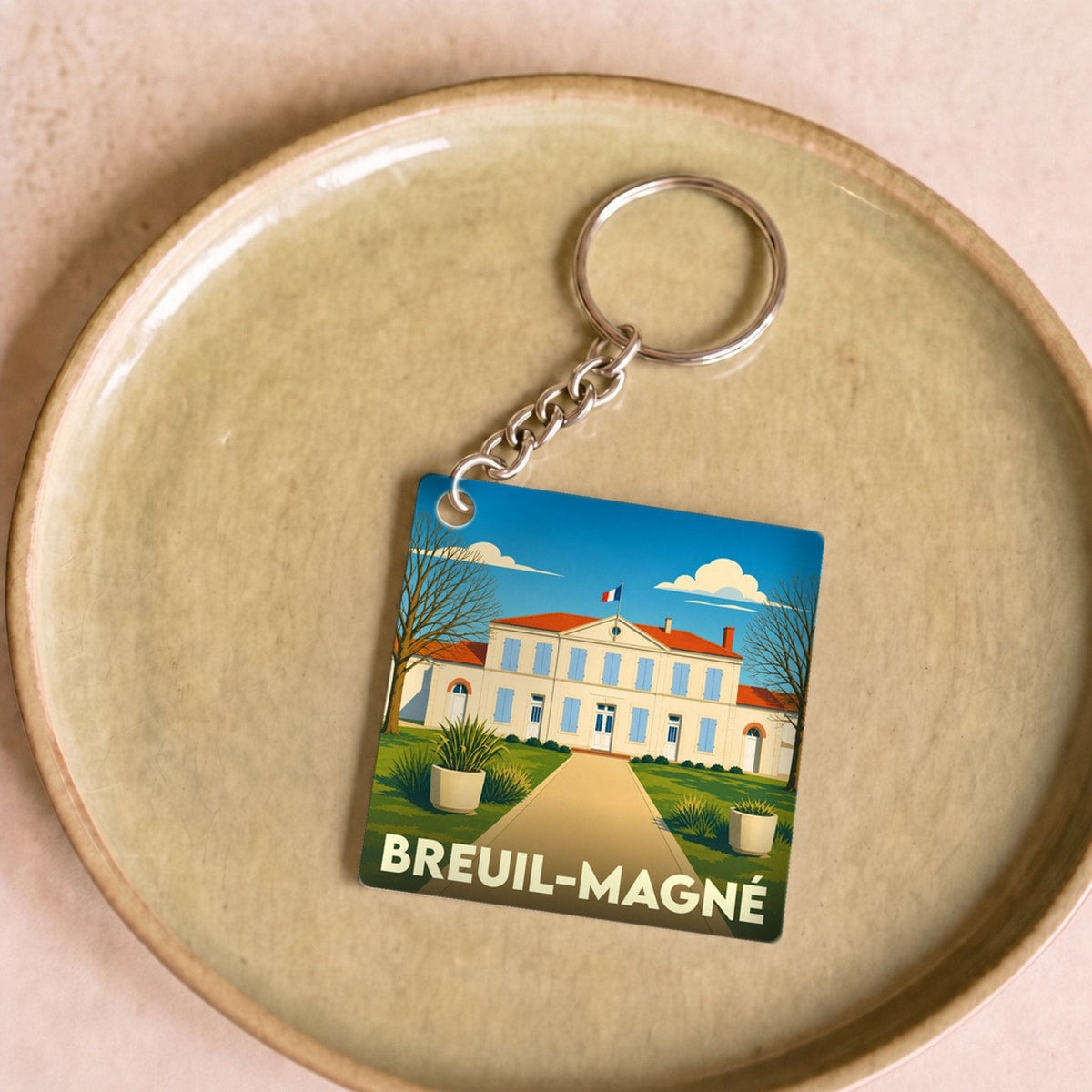Porte-clés souvenir de la ville de Breuil-Magné avec une illustration stylisée de sa mairie.