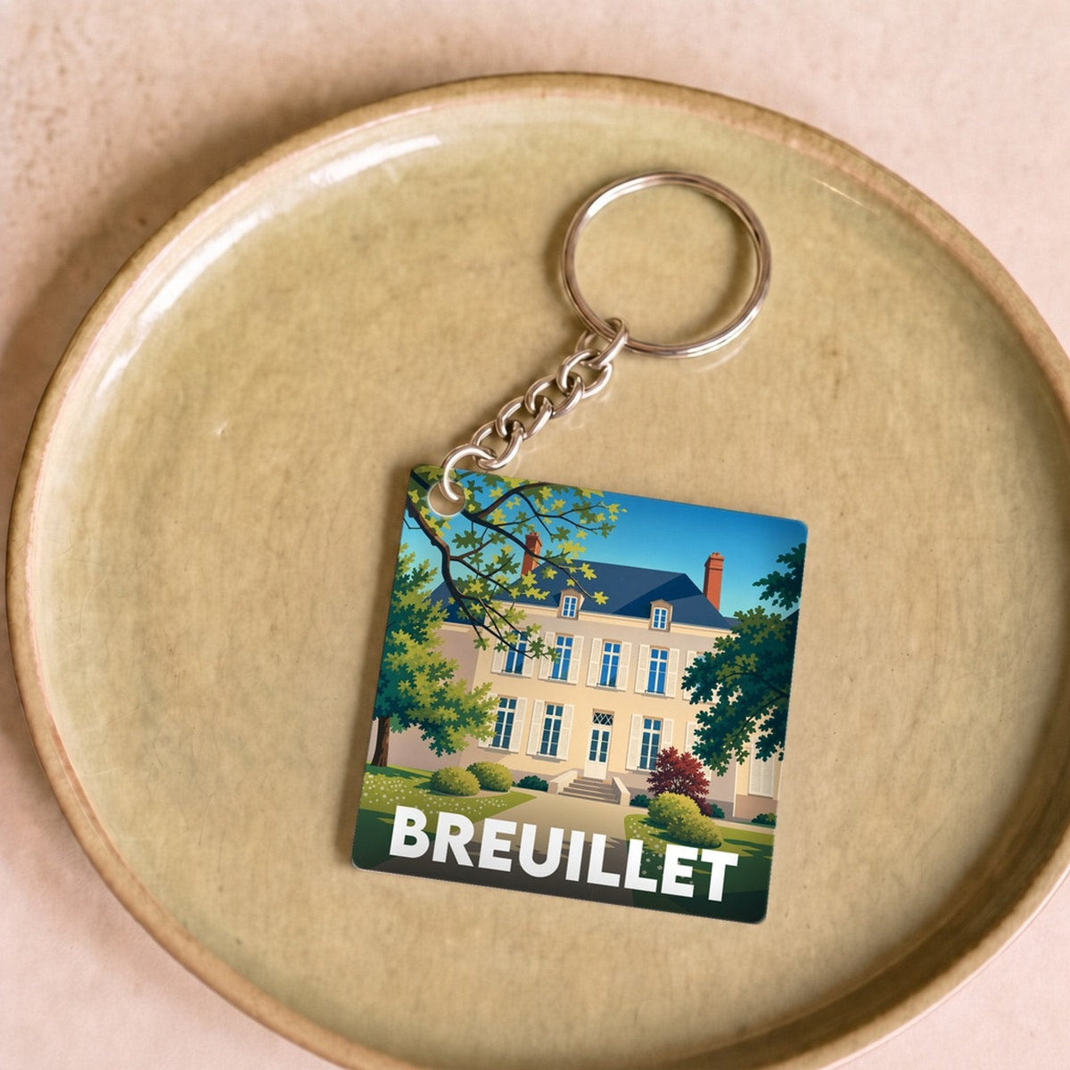 Porte-clés souvenir de la ville de Breuillet avec une illustration stylisée.
