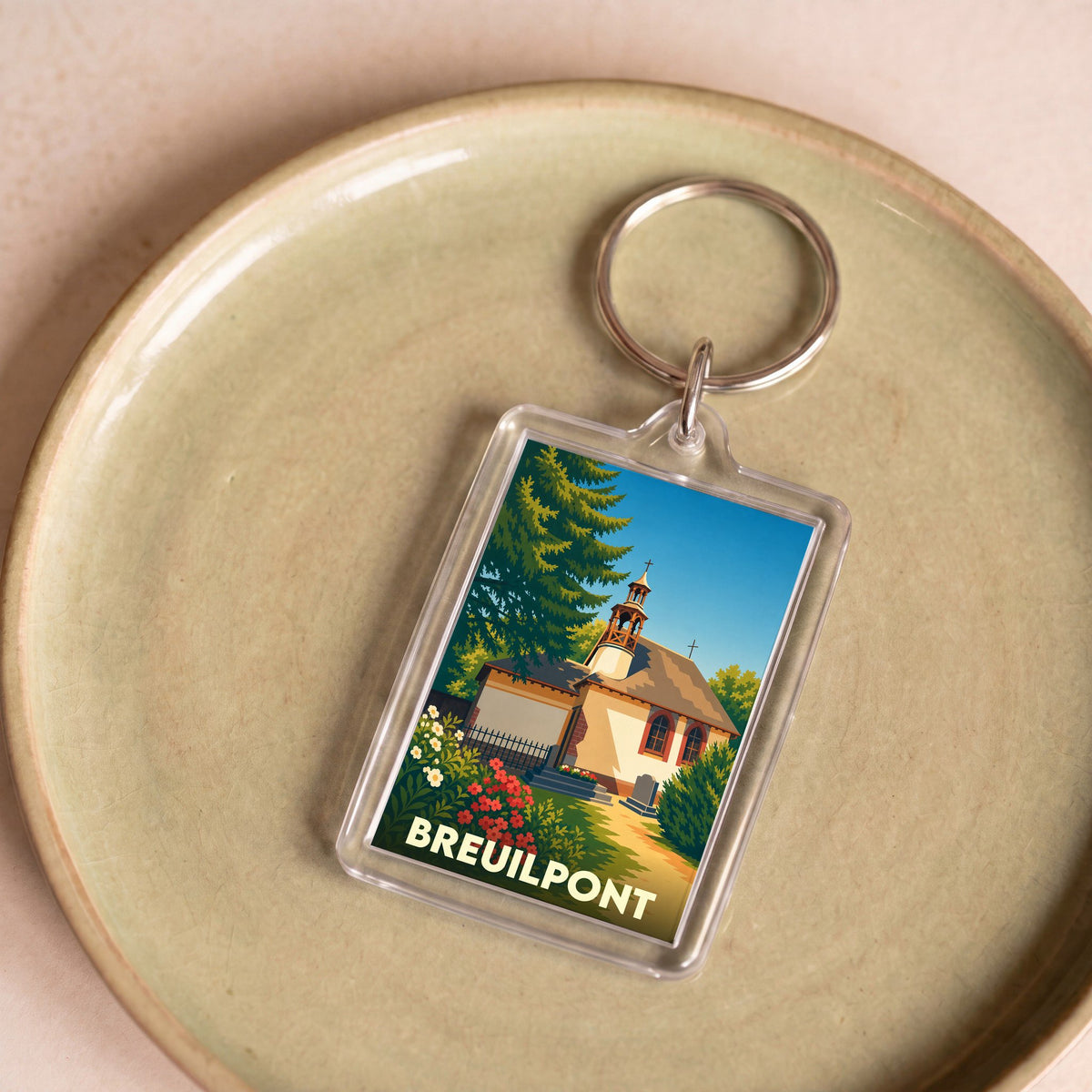 Porte-clés souvenir de la ville de Breuilpont avec une illustration stylisée de son église.