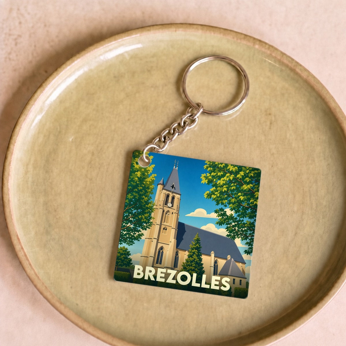 Porte-clés souvenir de la ville de Brezolles avec une illustration stylisée de son église.