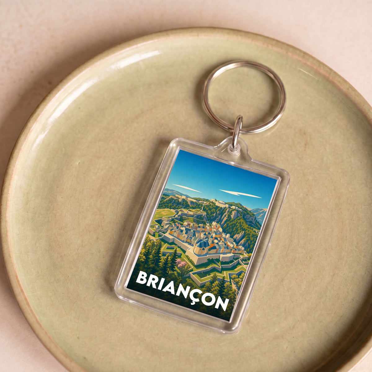 Porte-clés souvenir de la ville de Briançon avec une illustration stylisée des montagnes et des fortifications.