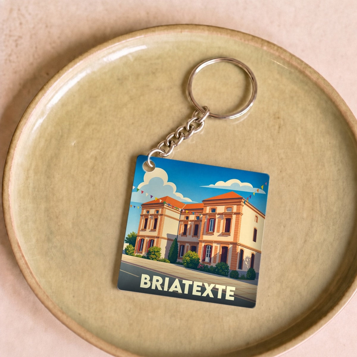 Porte-clés souvenir de la ville de Briatexte avec une illustration stylisée.