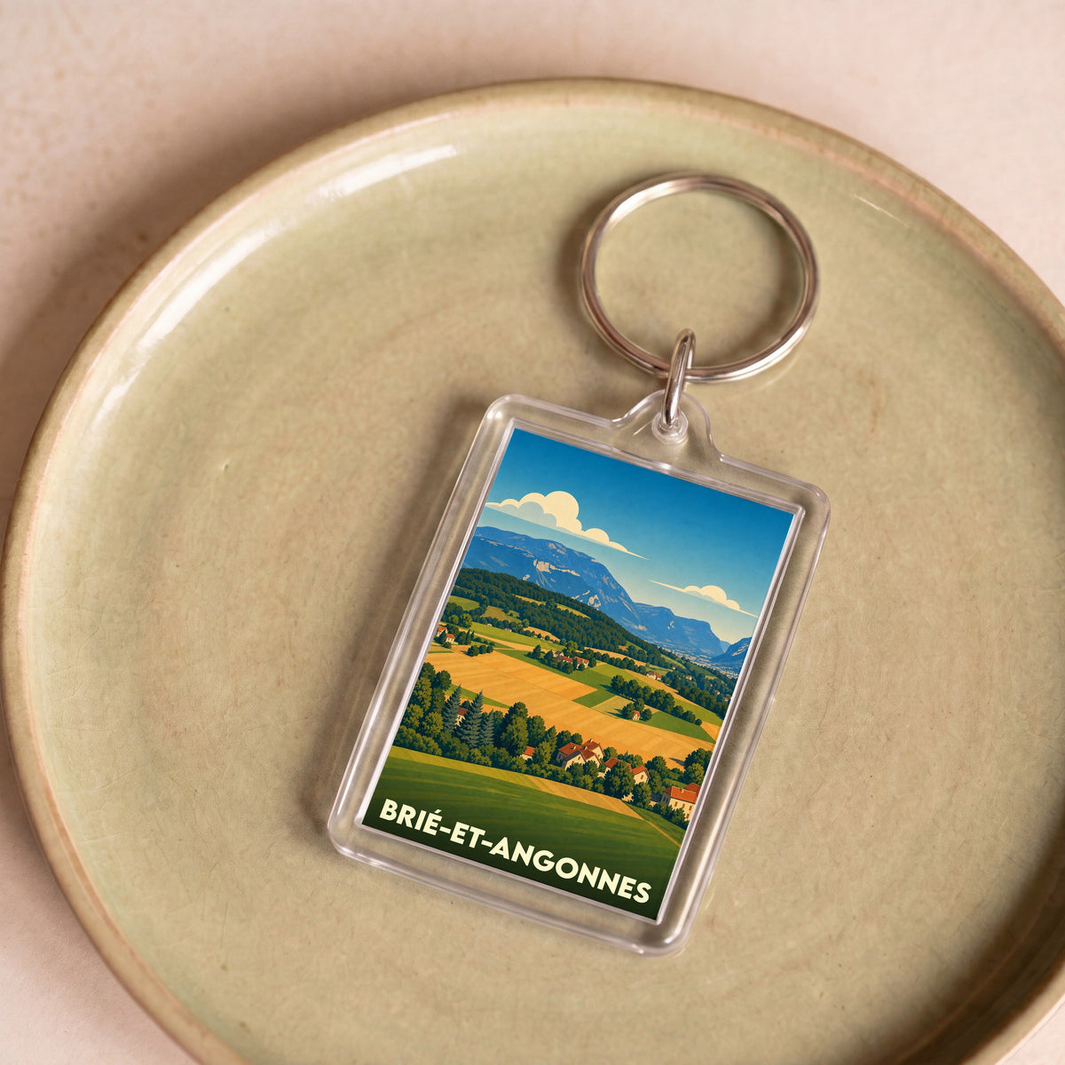 Porte-clés souvenir de la ville de Brié-et-Angonnes avec une illustration paysagère stylisée.