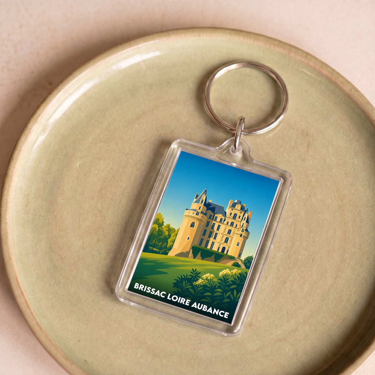 Porte-clés souvenir de Brissac Loire Aubance avec une illustration stylisée du château.