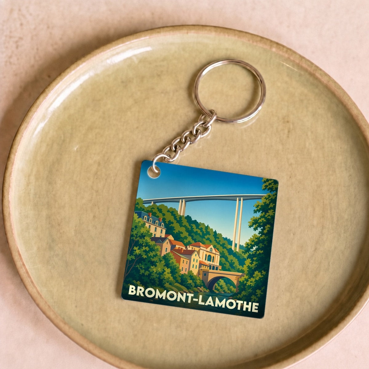 Porte-clés souvenir de la ville de Bromont-Lamothe avec une illustration stylisée.