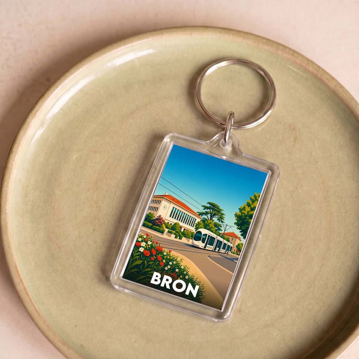 Porte-clés souvenir de la ville de Bron avec une illustration stylisée.