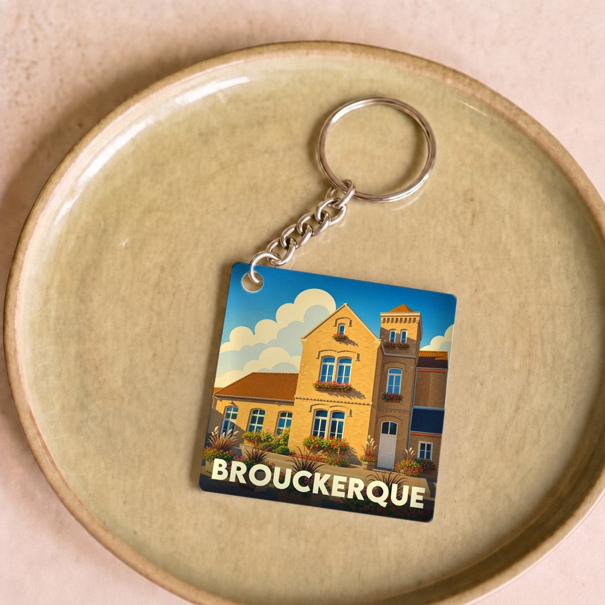 Porte-clés souvenir de la ville de Brouckerque avec une illustration stylisée.