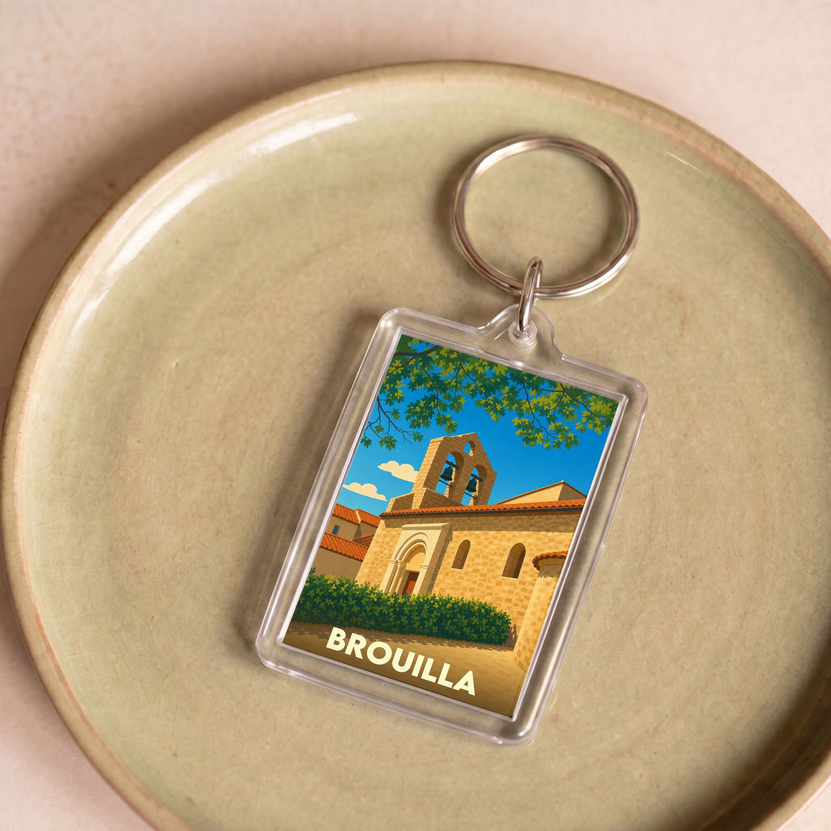 Porte-clés souvenir de la ville de Brouilla avec une illustration stylisée de son église.