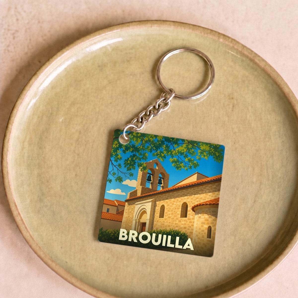 Porte-clés souvenir de la ville de Brouilla avec une illustration stylisée de son église.