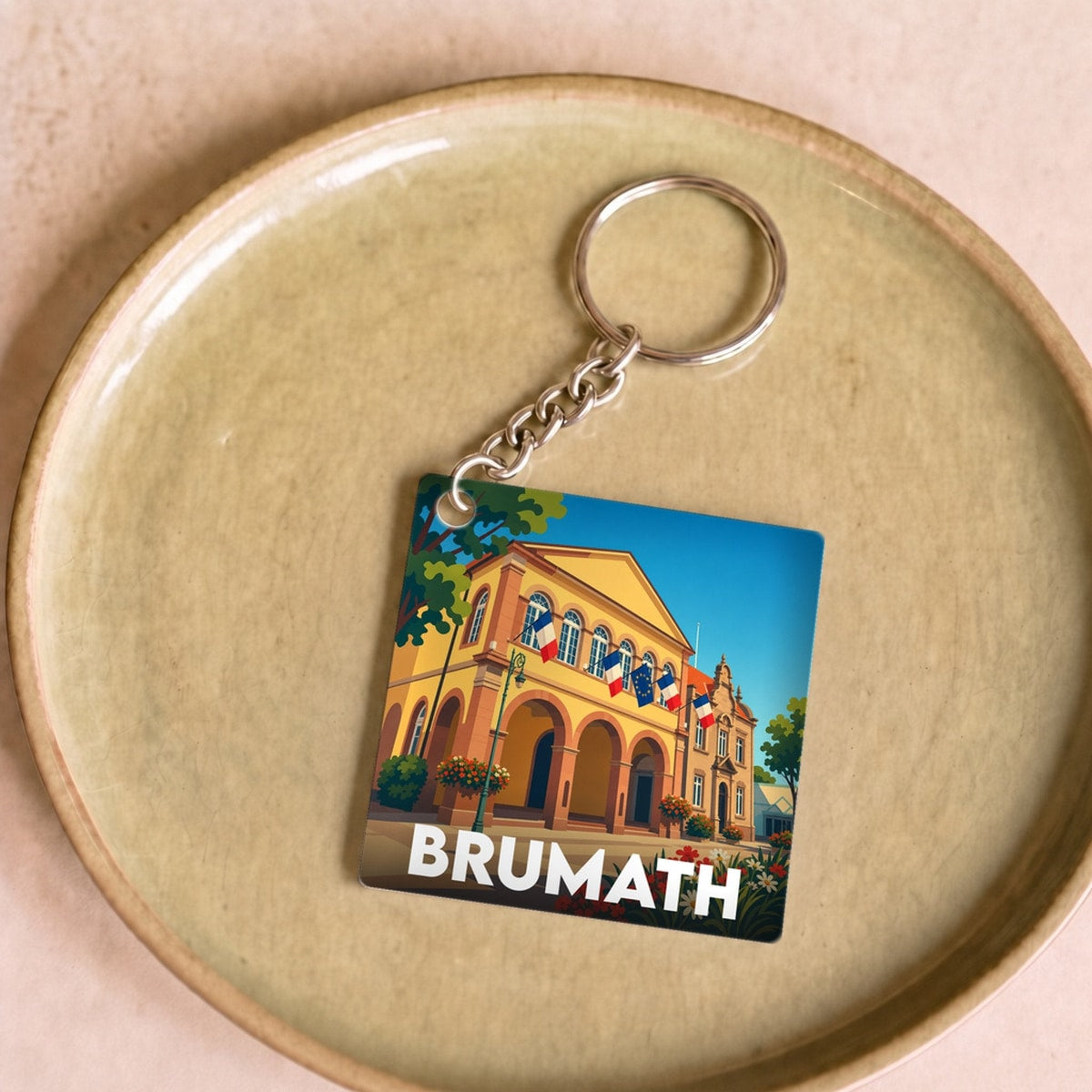Porte-clés souvenir de la ville de Brumath avec une illustration stylisée.