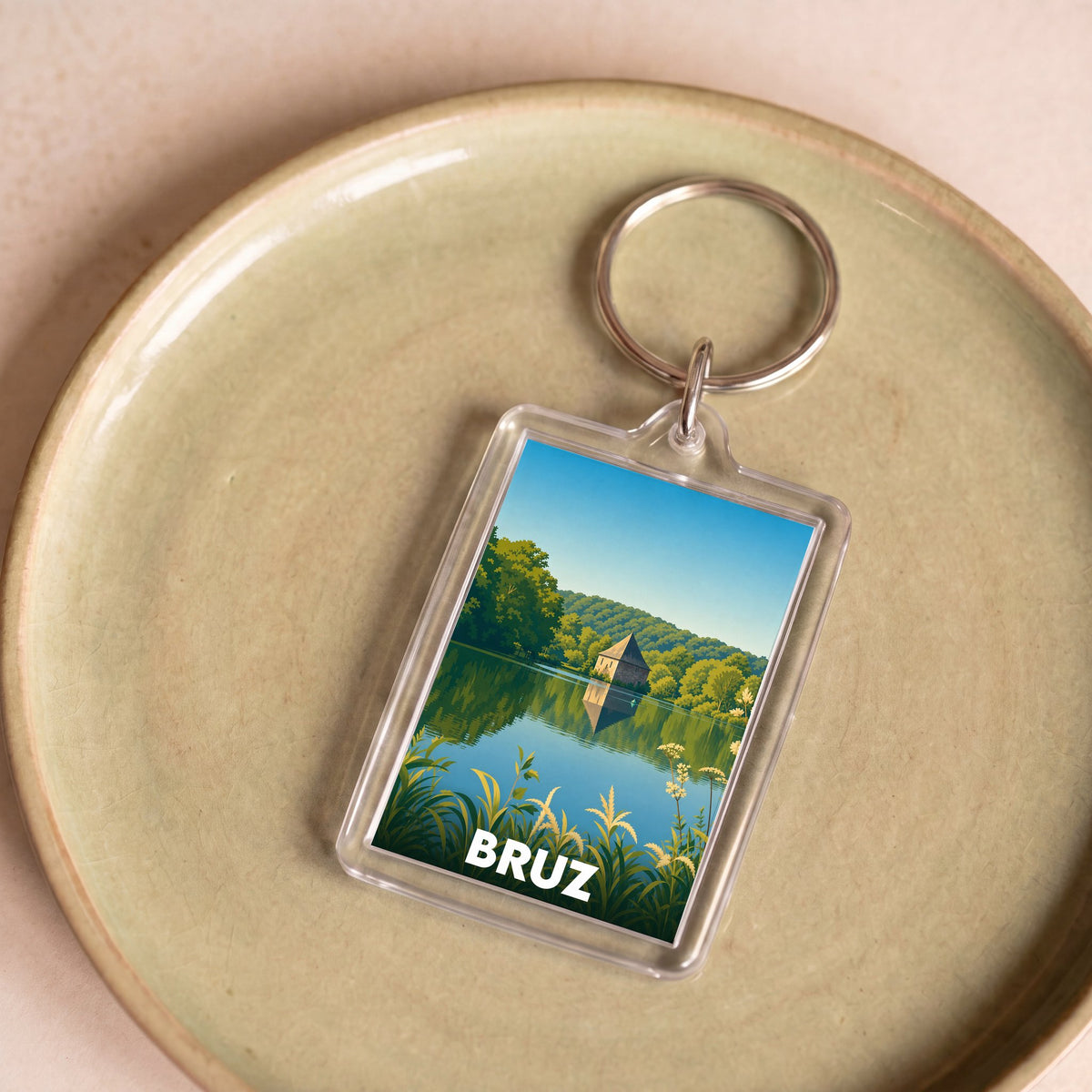 Porte-clés souvenir de la ville de Bruz avec une illustration stylisée d'un paysage de bord de l'eau.