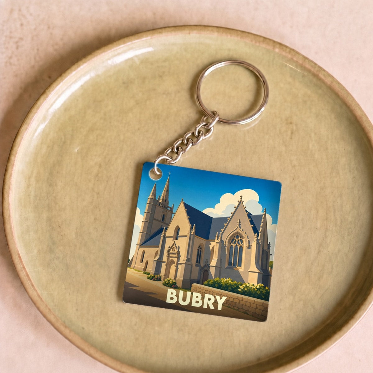 Porte-clés souvenir de la ville de Bubry avec une illustration stylisée de son église.