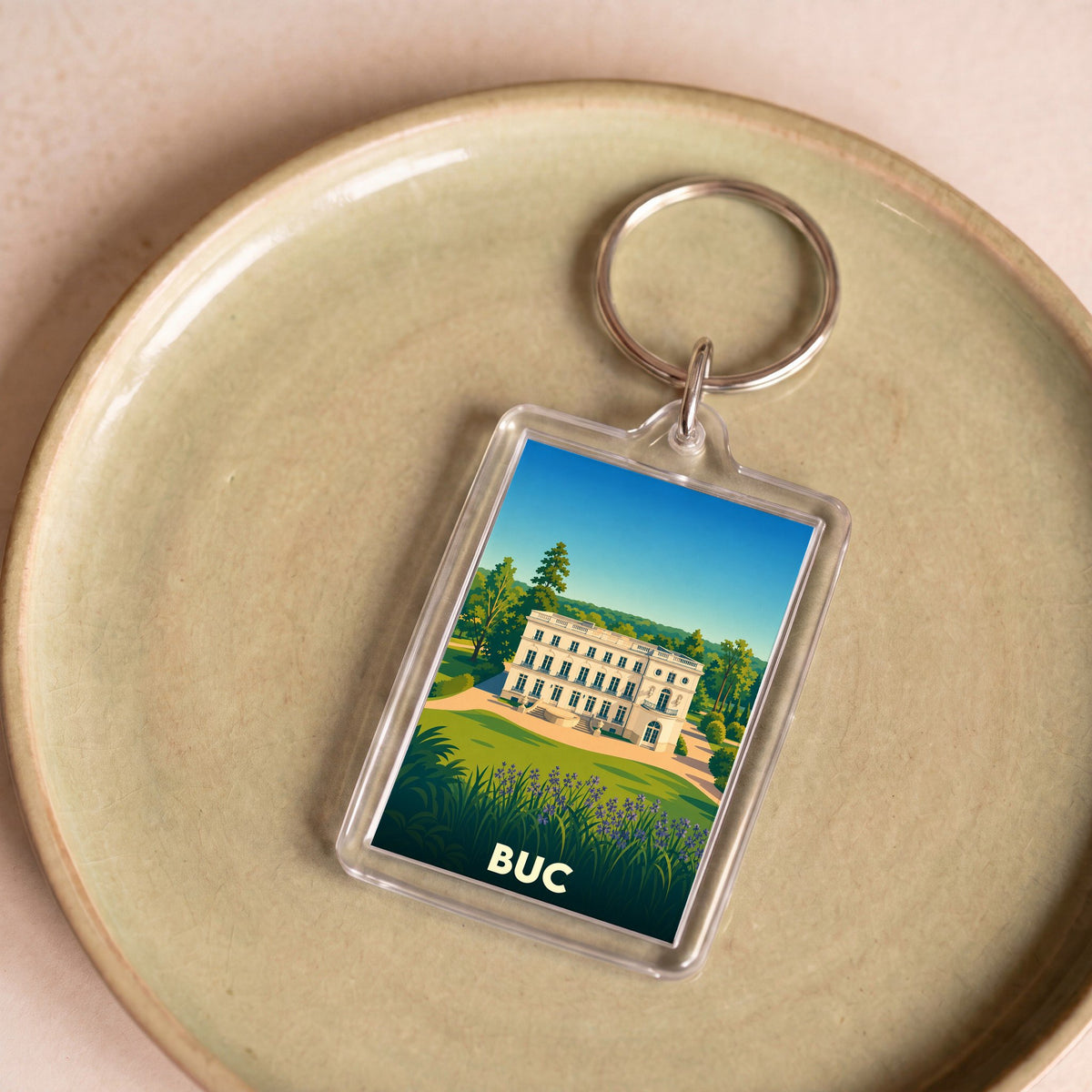 Porte-clés souvenir de la ville de Buc avec une illustration stylisée de son château.