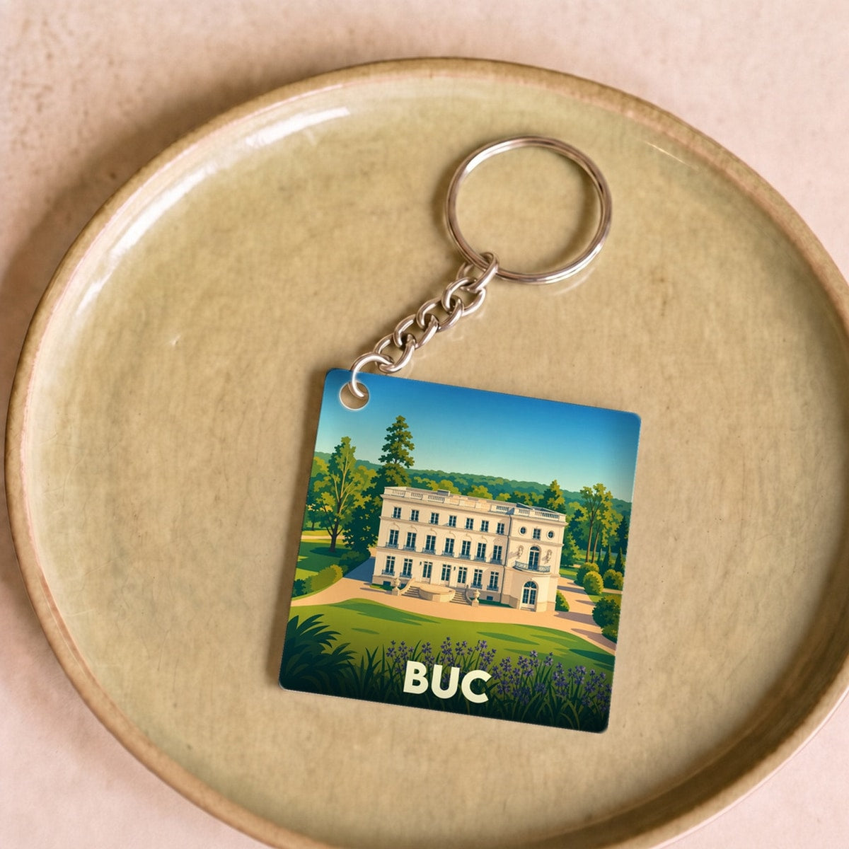 Porte-clés souvenir de la ville de Buc avec une illustration stylisée de son château.
