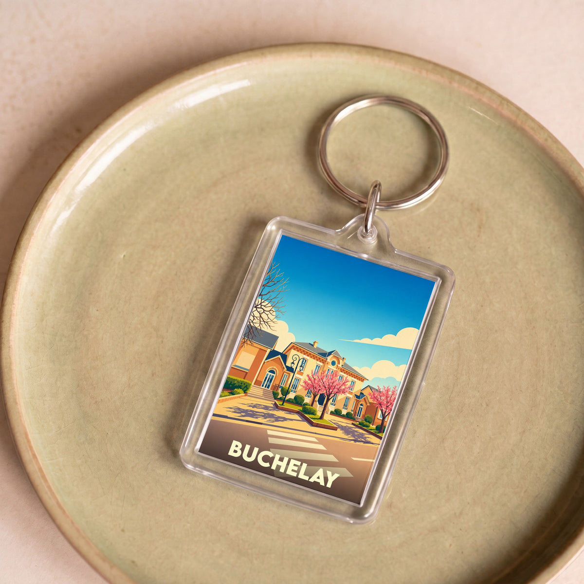 Porte-clés souvenir de la ville de Buchelay avec une illustration stylisée.