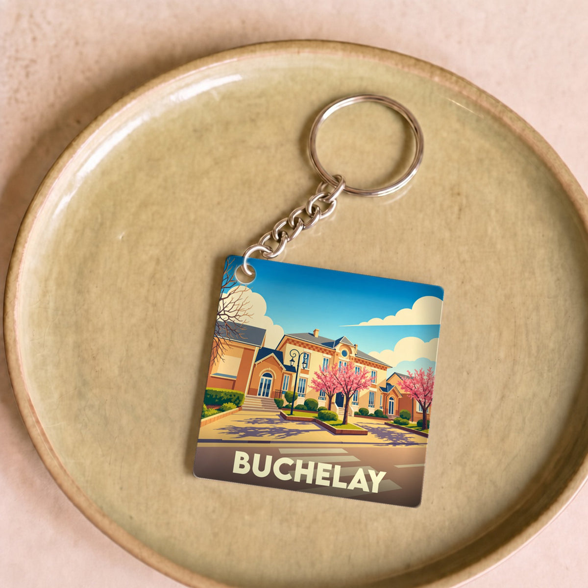 Porte-clés souvenir de la ville de Buchelay avec une illustration stylisée.