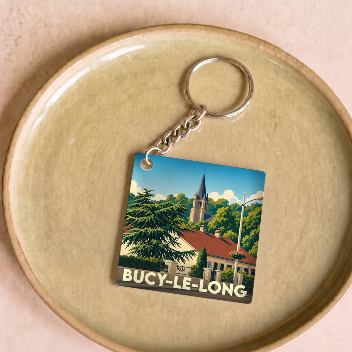 Porte-clés souvenir de la ville de Bucy-le-Long avec une illustration stylisée.