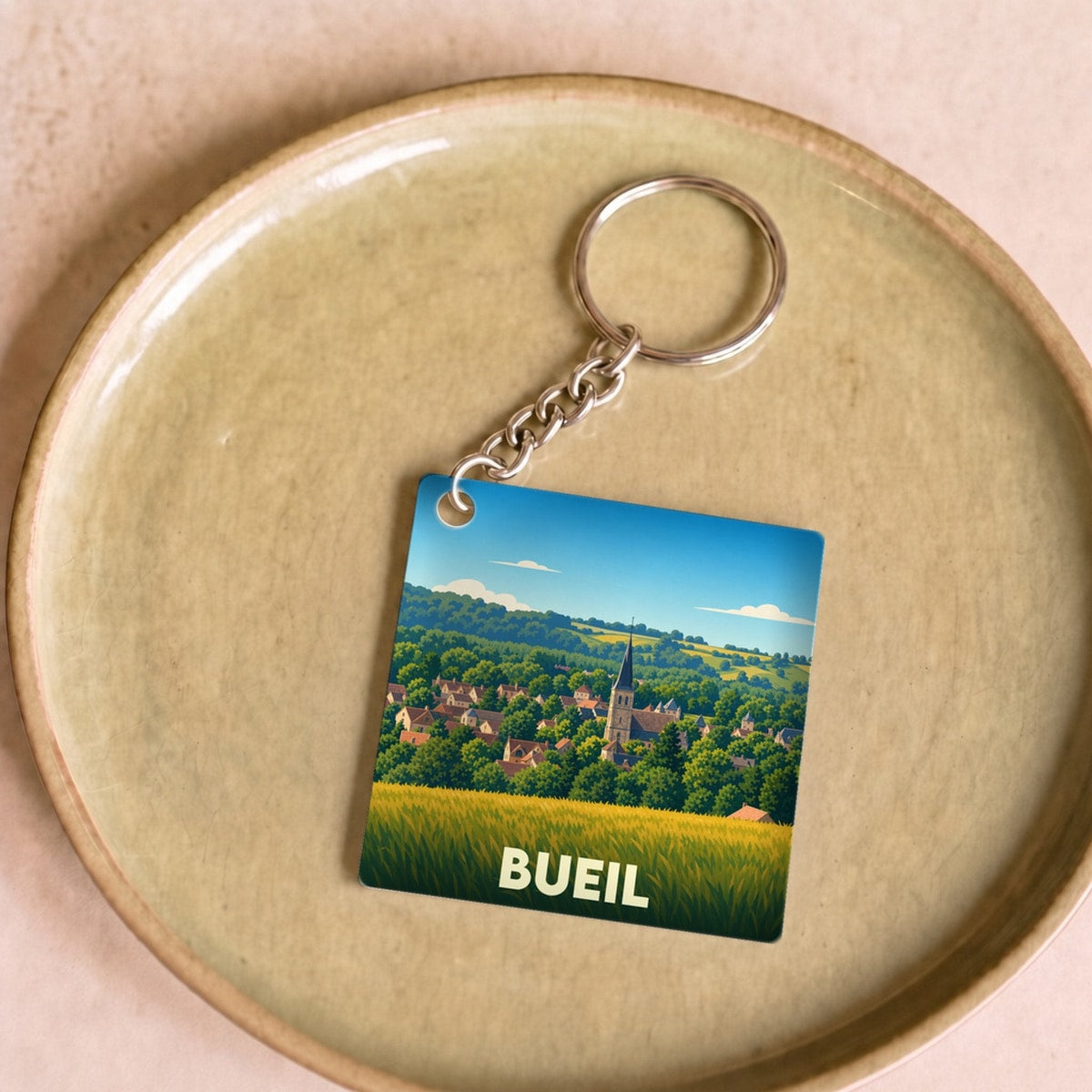 Porte-clés souvenir de la ville de Bueil avec une illustration stylisée.