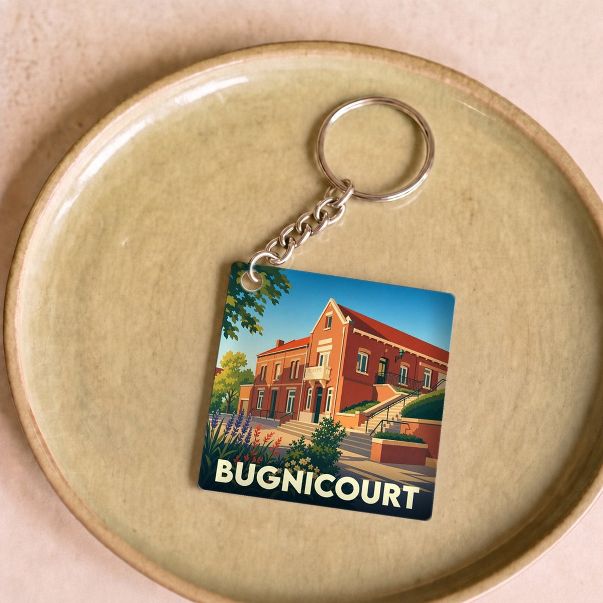 Porte-clés souvenir de la ville de Bugnicourt avec une illustration stylisée de sa mairie.