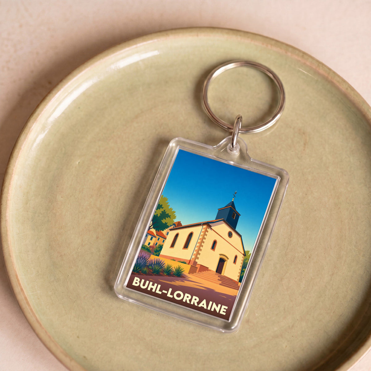 Porte-clés souvenir de la ville de Buhl-Lorraine avec une illustration stylisée d'une église locale.
