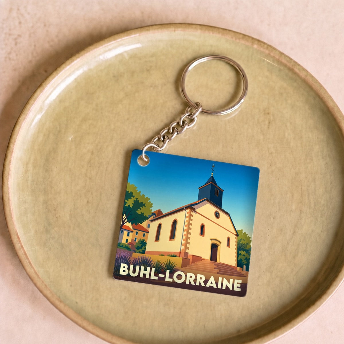 Porte-clés souvenir de la ville de Buhl-Lorraine avec une illustration stylisée d'une église locale.