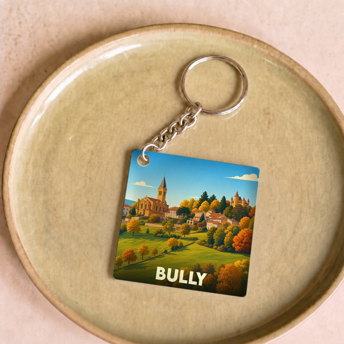 Porte-clés souvenir de la ville de Bully avec une illustration stylisée de son paysage.