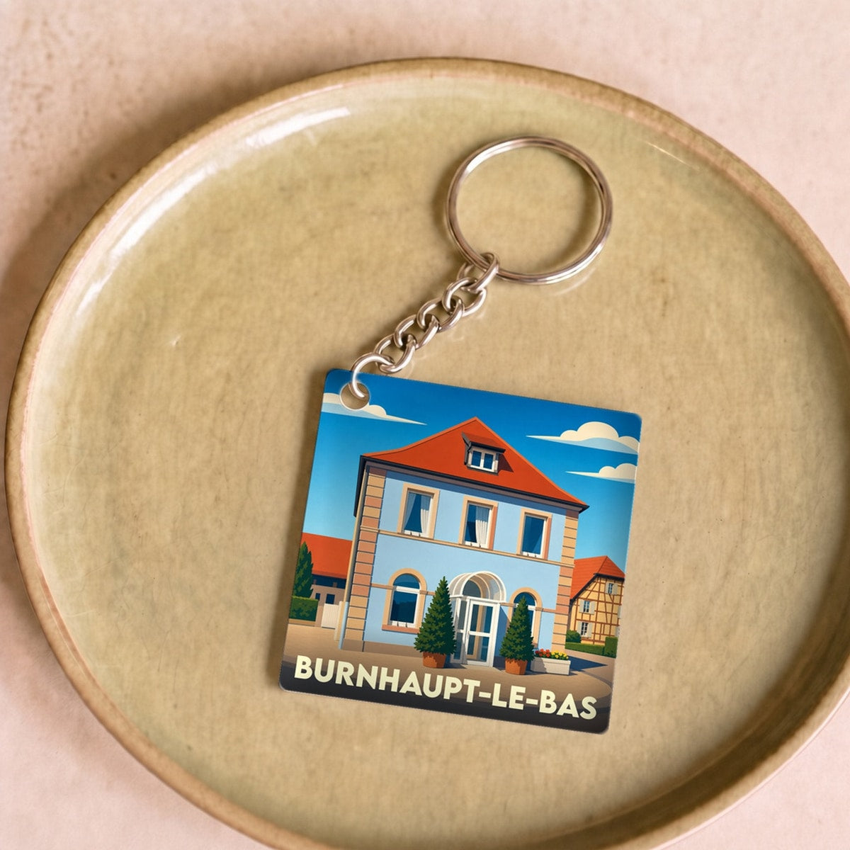 Porte-clés souvenir de la ville de Burnhaupt-le-Bas avec une illustration stylisée.