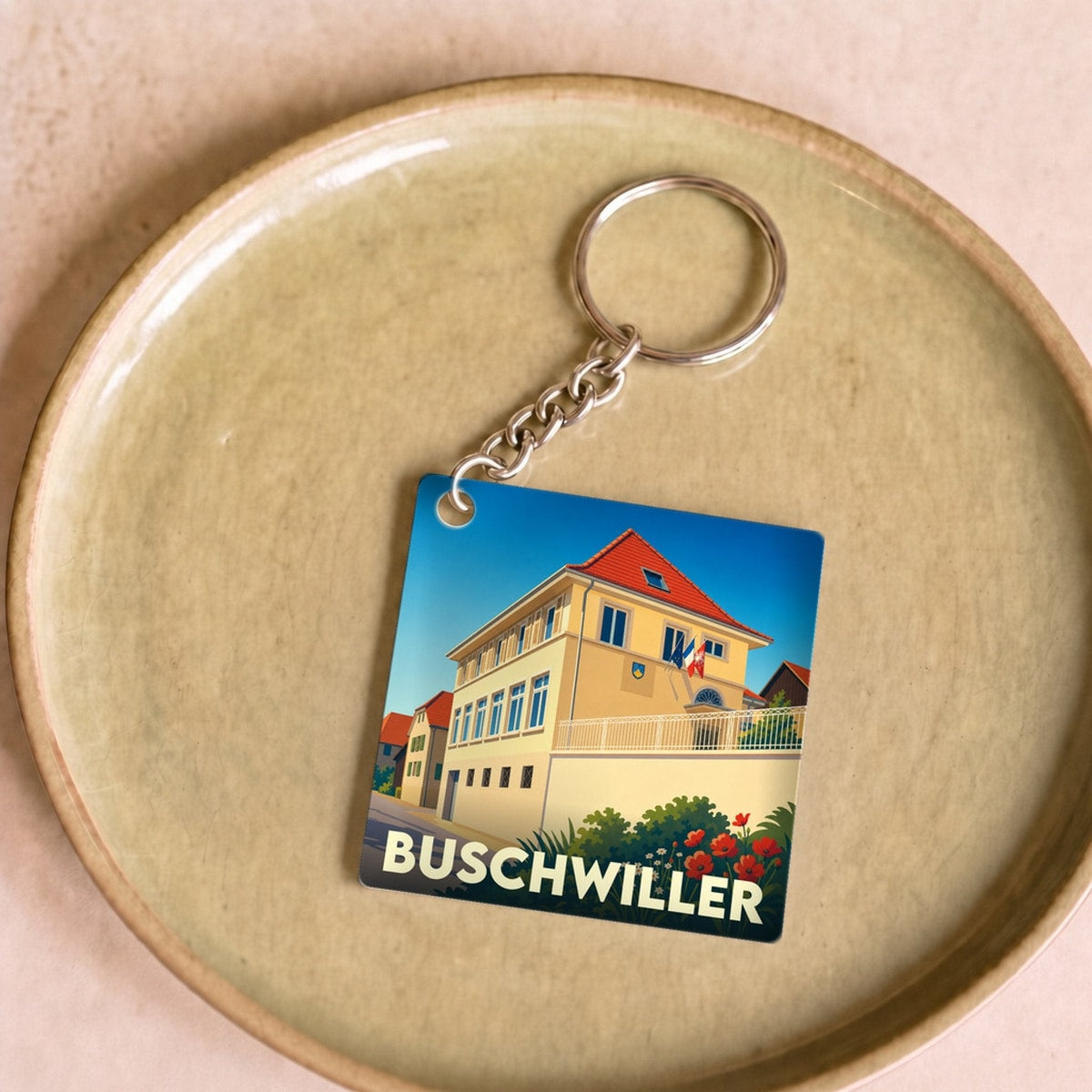 Porte-clés souvenir de la ville de Buschwiller avec une illustration stylisée.
